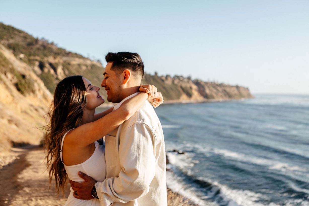 Engaged couple embracing on a coastal cliff during a session with Bay Area wedding photographers
