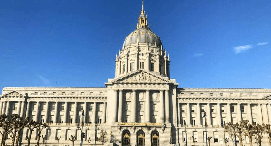 The domed Beaux-Arts facade of San Francisco City Hall under a clear blue sky