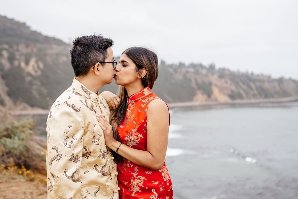 Couple sharing a kiss along the California coastline, highlighting how to choose a wedding photographer for natural and timeless portraits.