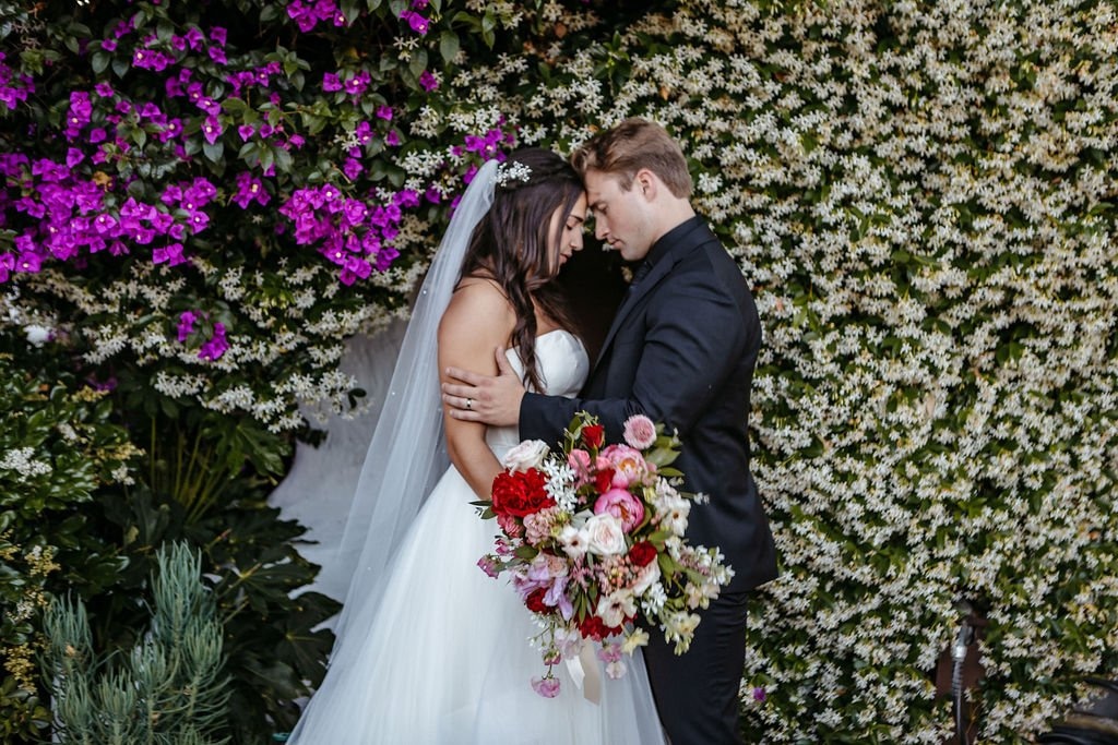 Bride and groom embracing in a lush garden setting, highlighting how to select a wedding photographer whose style matches your vision and venue.