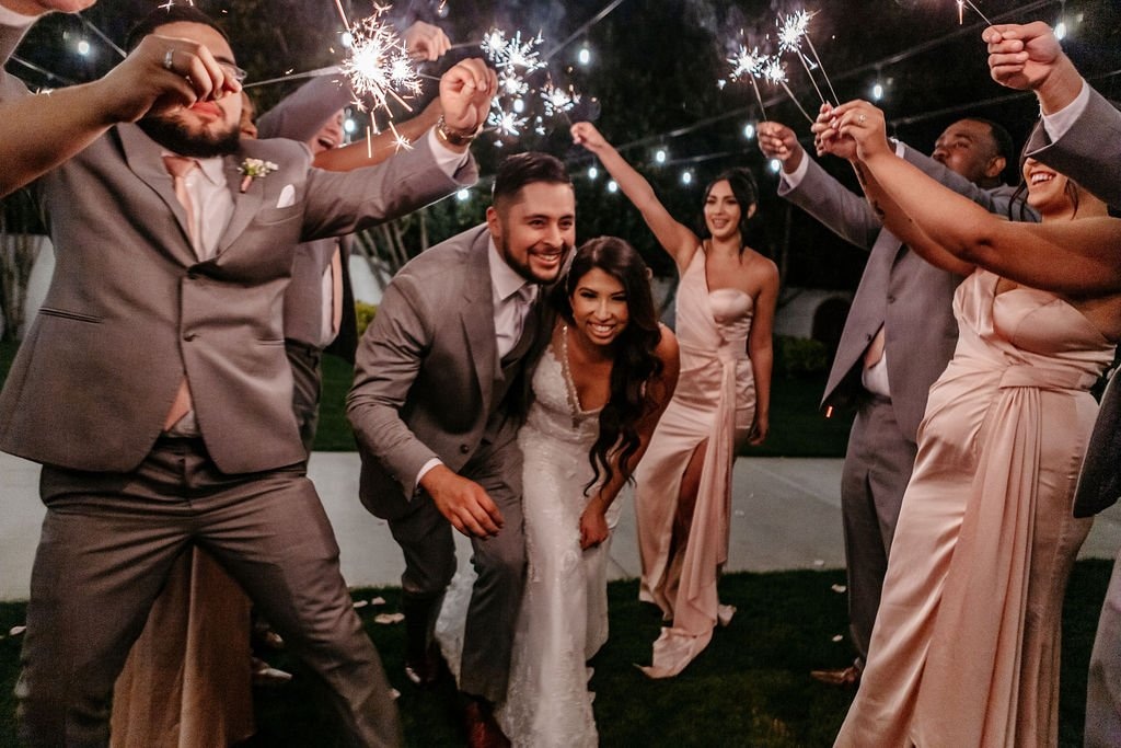 Bride and groom celebrating a sparkler exit with friends and family, showcasing how wedding photographers in San Francisco CA capture joyful moments and wedding-day excitement.